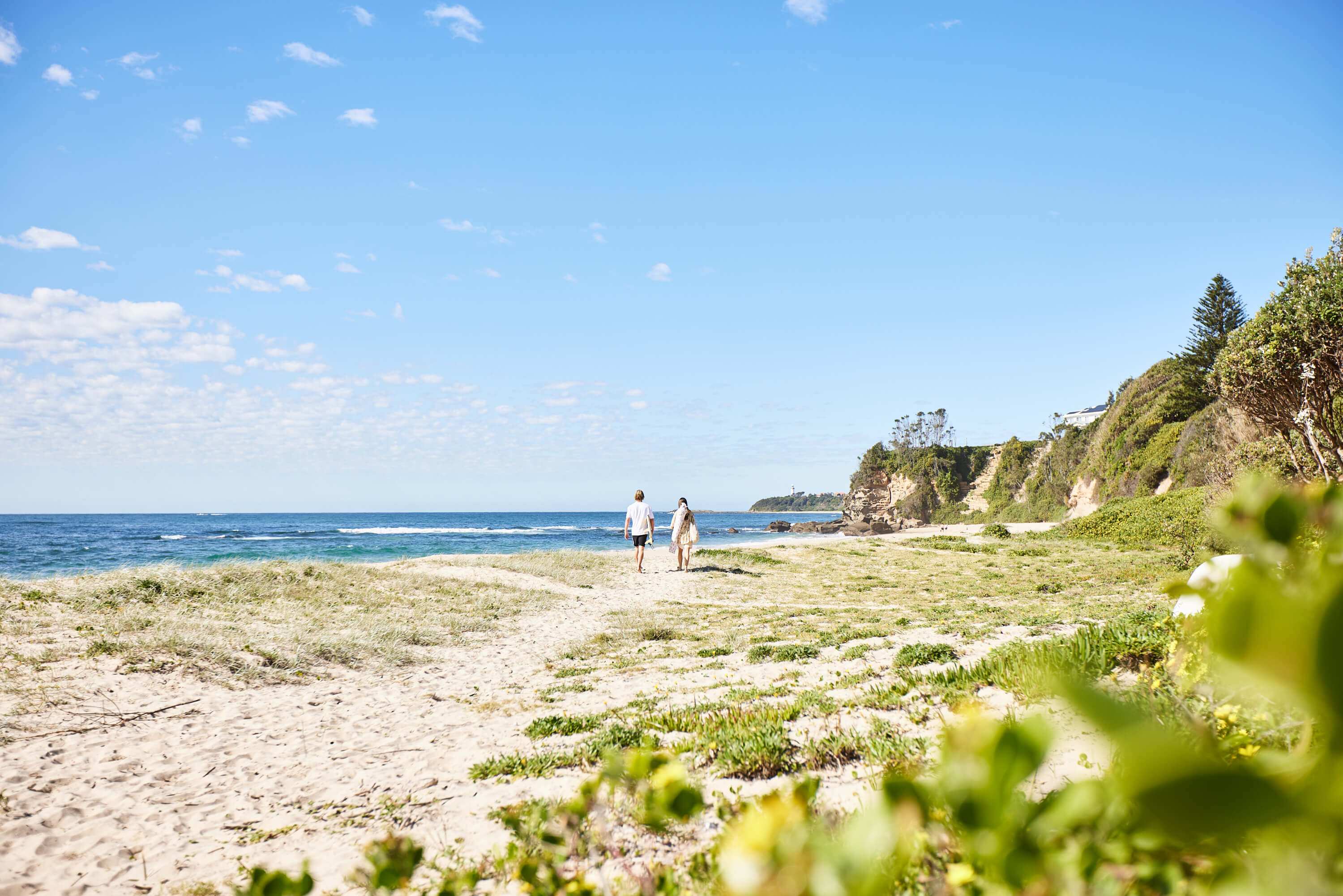 Couple strolling sandy beach shore