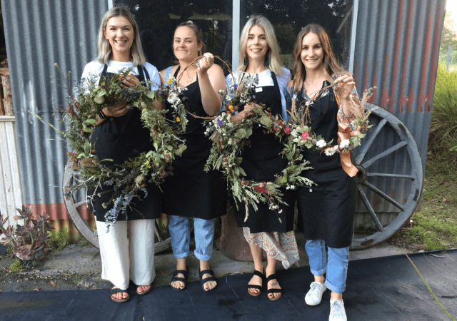 women holding floral wreaths