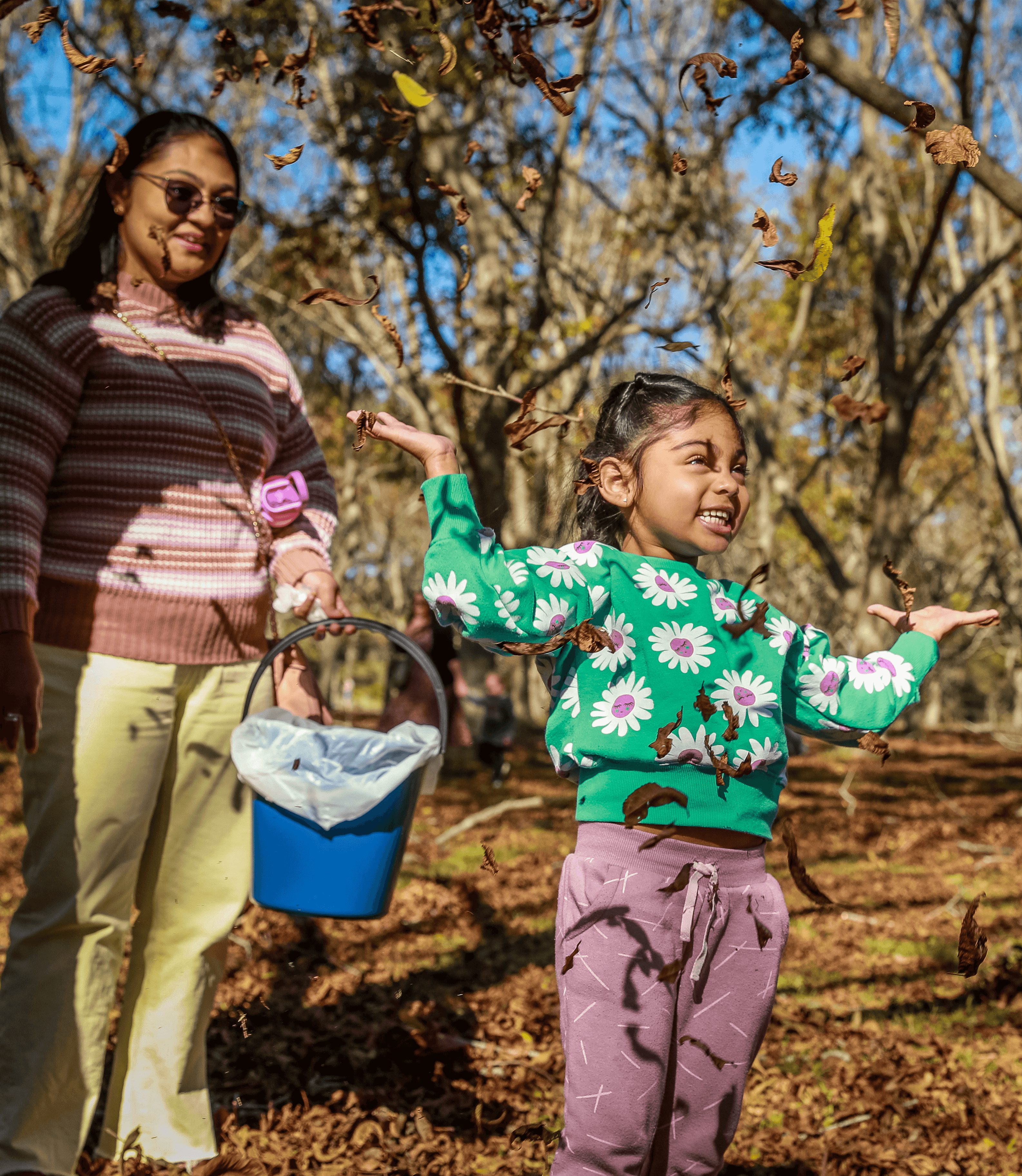 Young girl throwing leaves in pecan orchards Harvest Festival