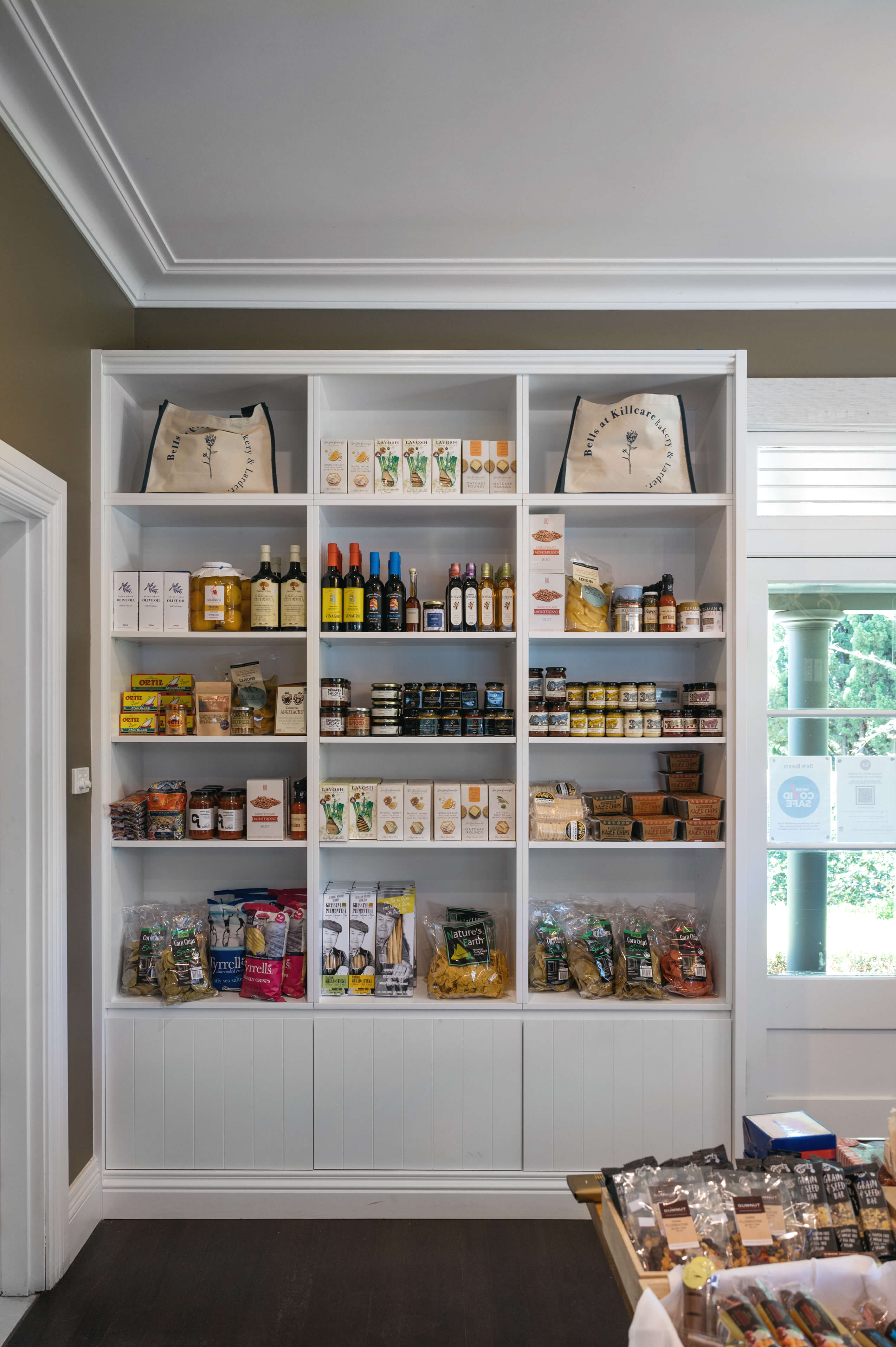 White shelving unit filled with preserves and canned locally made goods