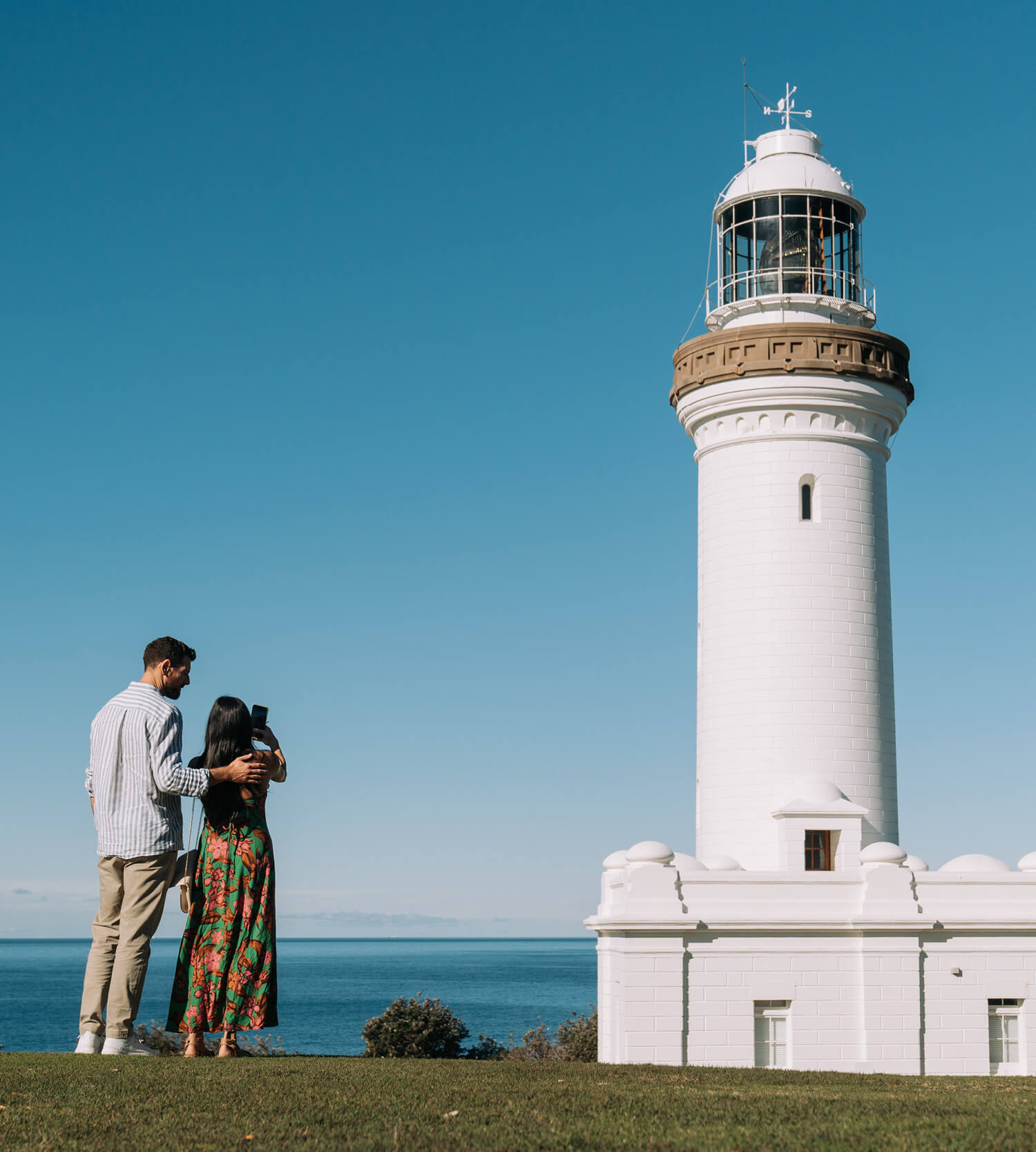 Couple taking photo of the iconic Norah Head Lighthouse 