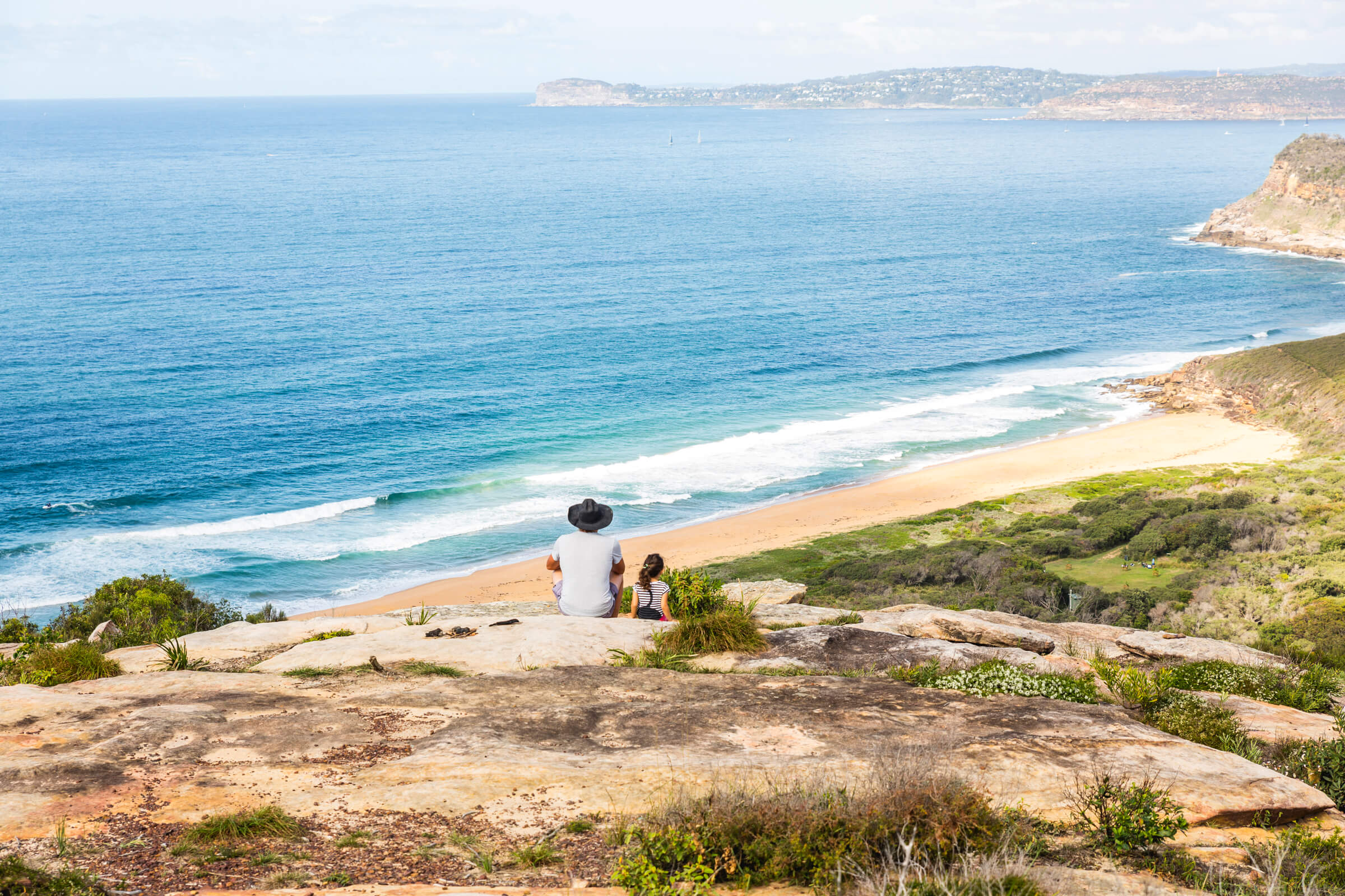 people watching coastline from headland lookout