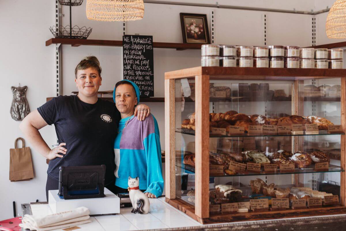 partners and owners of burnt honey bakery stand proudly behind the counter