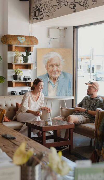couple in cafe in front of sir david attenborough painting