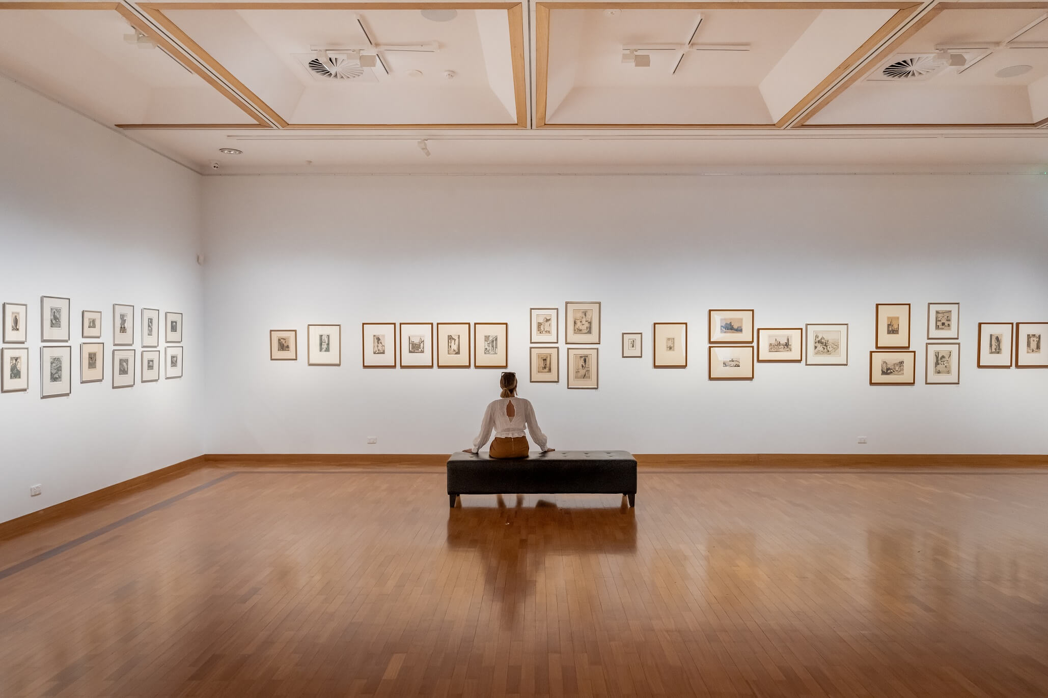 Woman looking at the art adorning the walls of the Gosford Regional Gallery