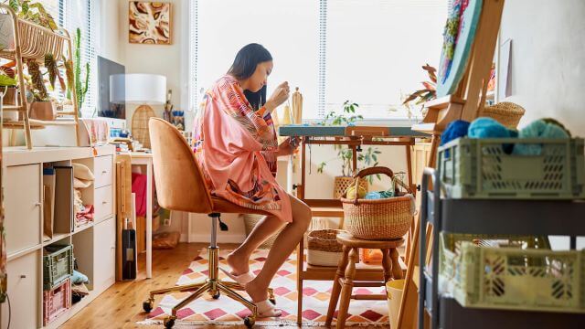 woman weaving handmade art in studio