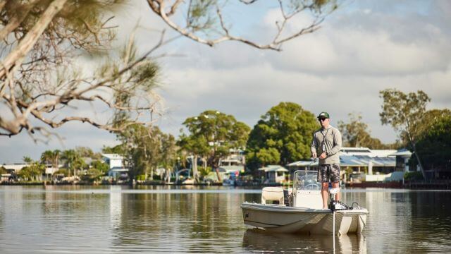 man fishing near lakeside houses