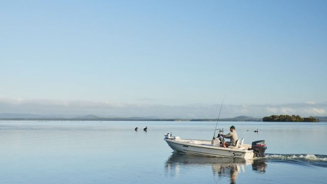 man on boat on lake fishing