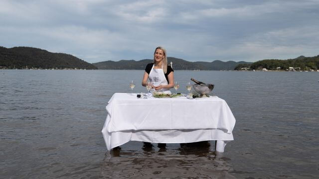 shucking oysters in river with waders on