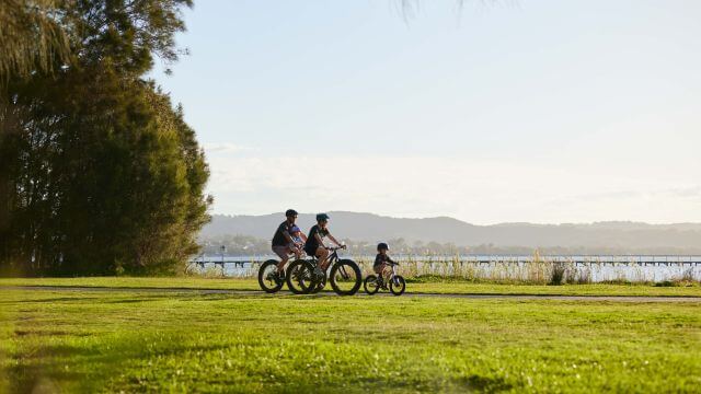 family cycling the lake foreshore