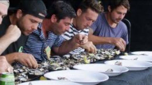 people eating oysters in a line up