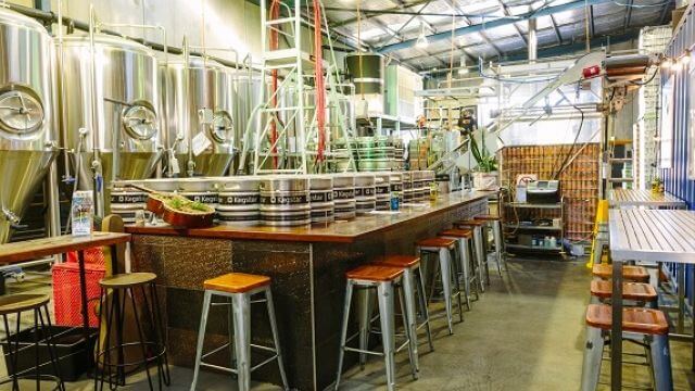 The bar sitting in front of vats at Six Strings Brewery at Erina