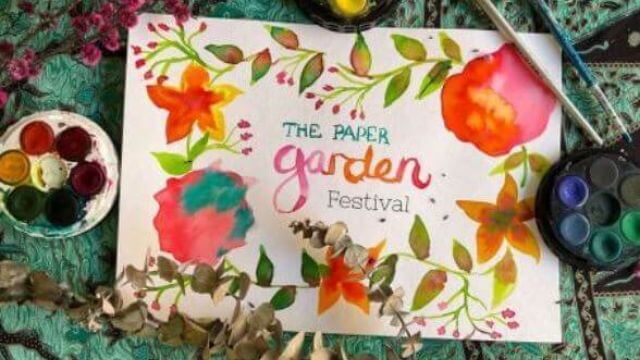 The Paper Garden title painted with paints, brushes and plants surrounding it
