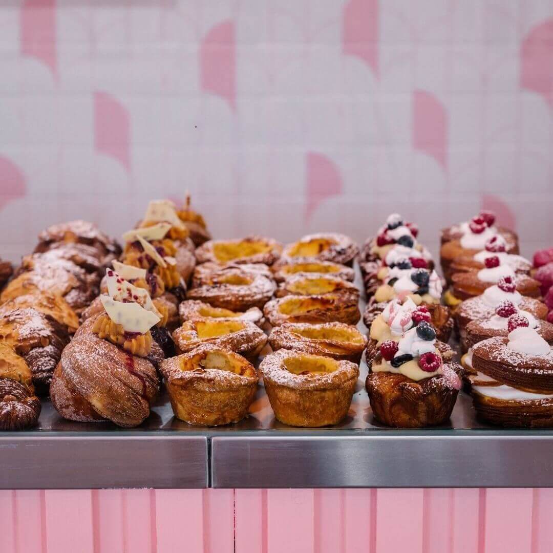 lineup of heaps of sweet pastries behind glass counter