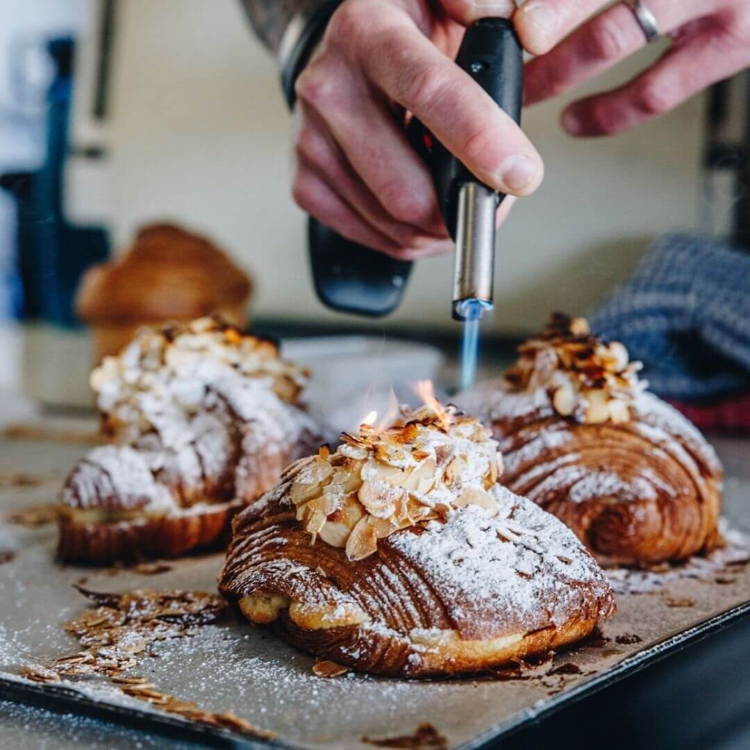 bow torching almond croissants