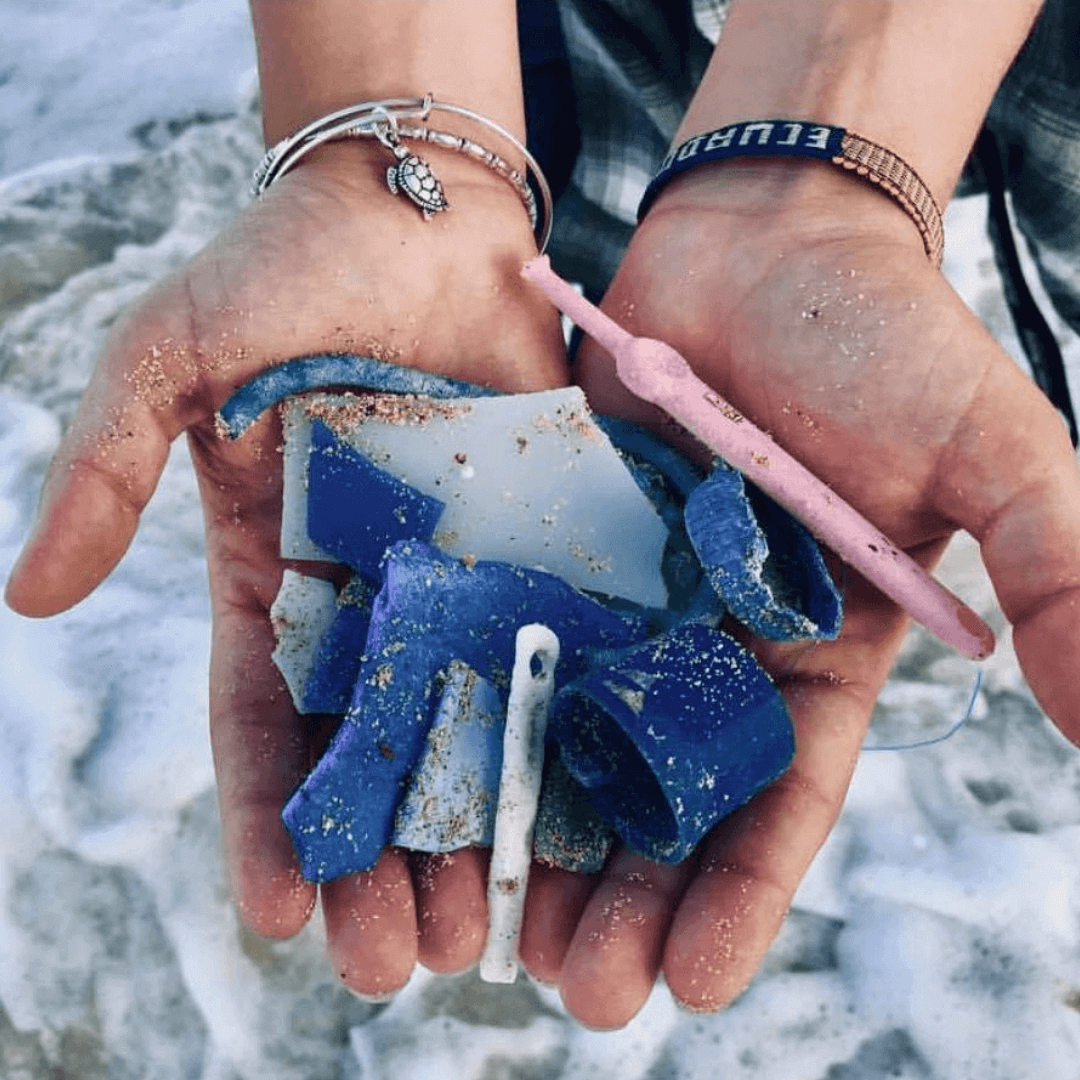 Hands holding rubbish from the ocean