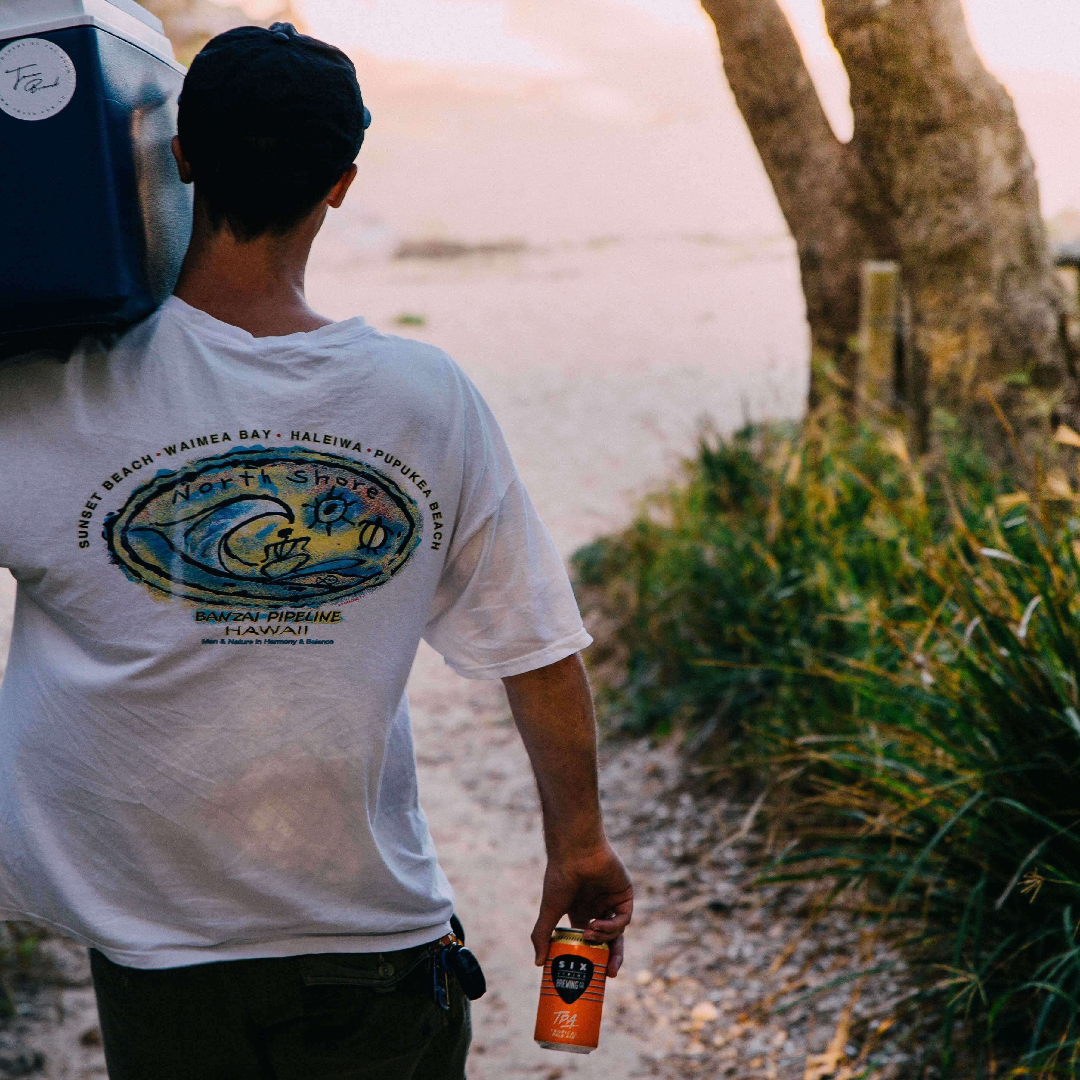 man on beach with esky of beer