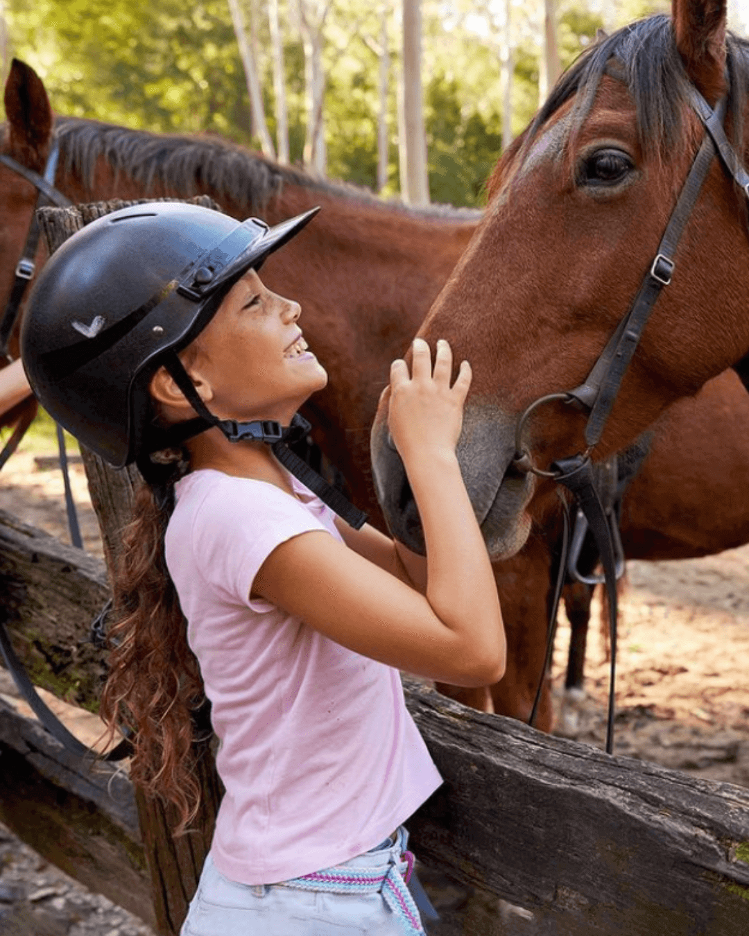 girl pats horse in stables