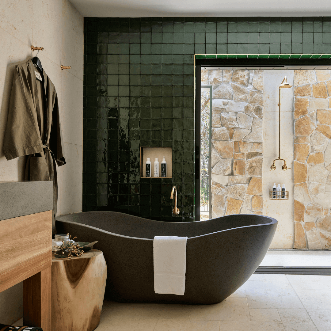 Charcoal bath with green shiny tile background and sandstone finishes