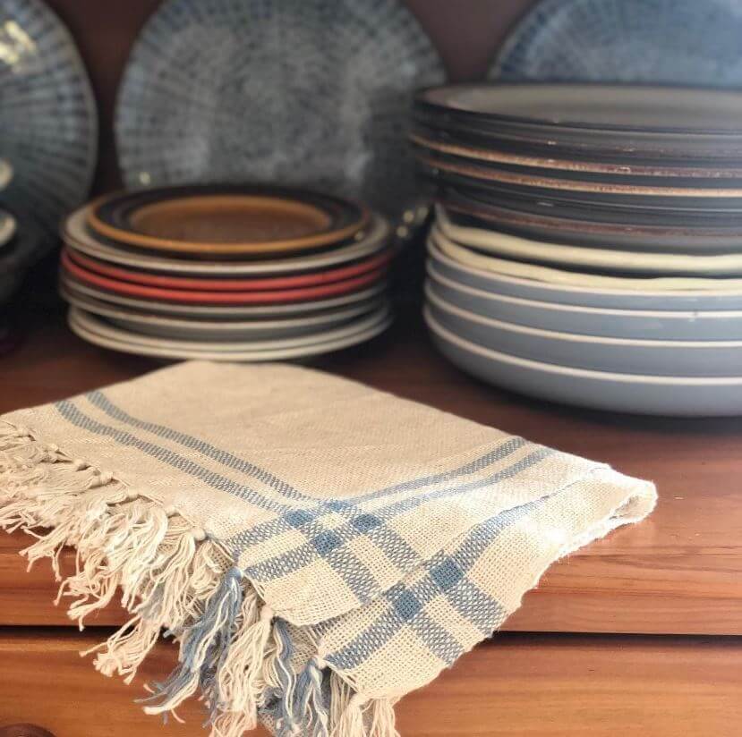 White and blue tea towel on wooden table