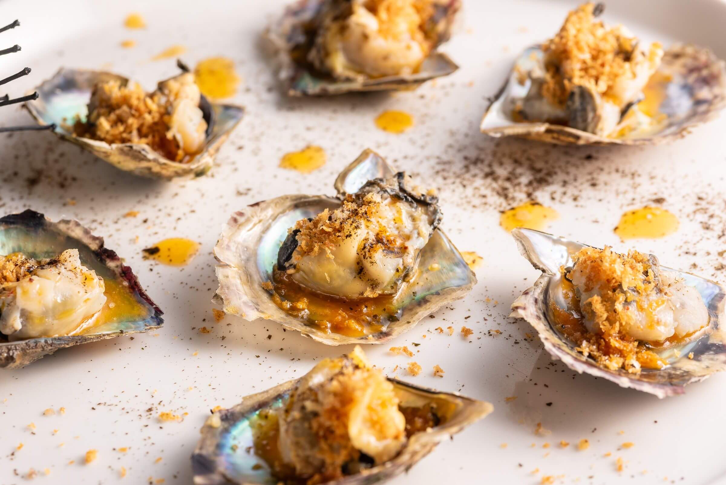 akoya pearl oysters prepared and laid out with chef garnish