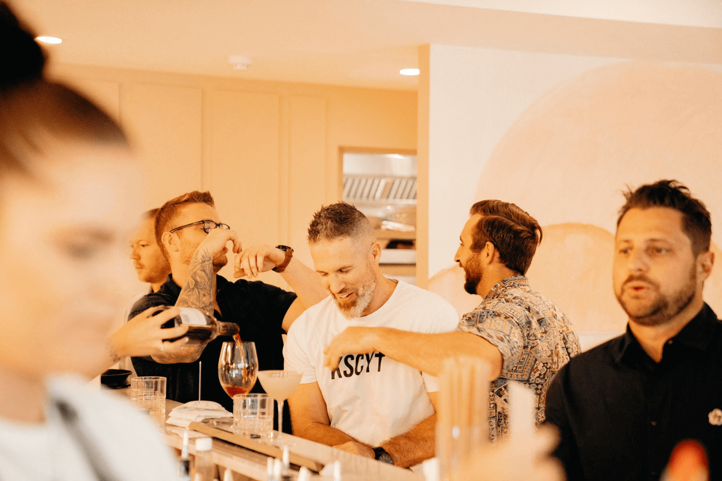 Men still in a trendy bar laughing and enjoying beers