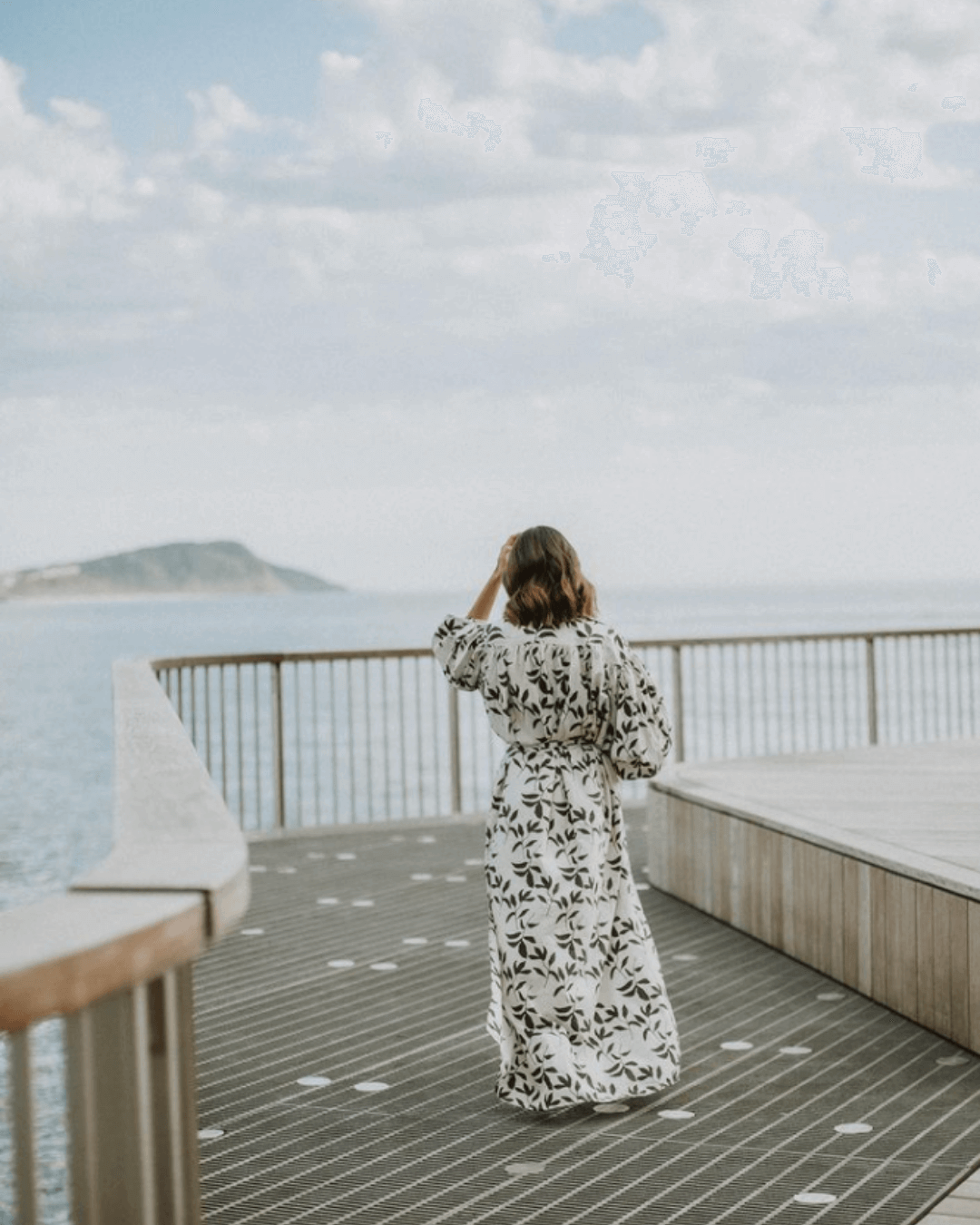 woman walks onto terrigal boardwalk in soft light