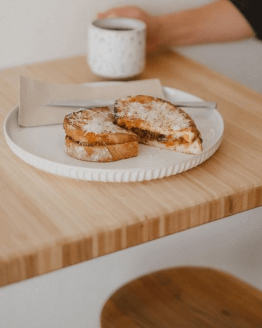 toastie covered in cheese with batch brew coffee in ceramic mug