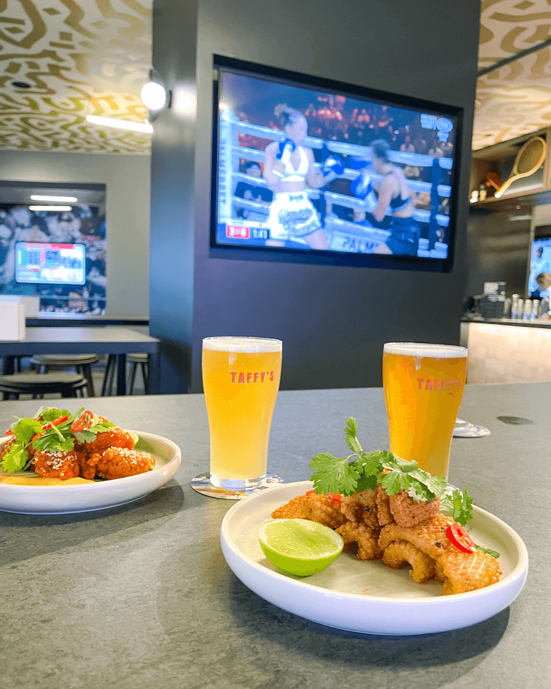 fresh beers and asian food on table at sports bar