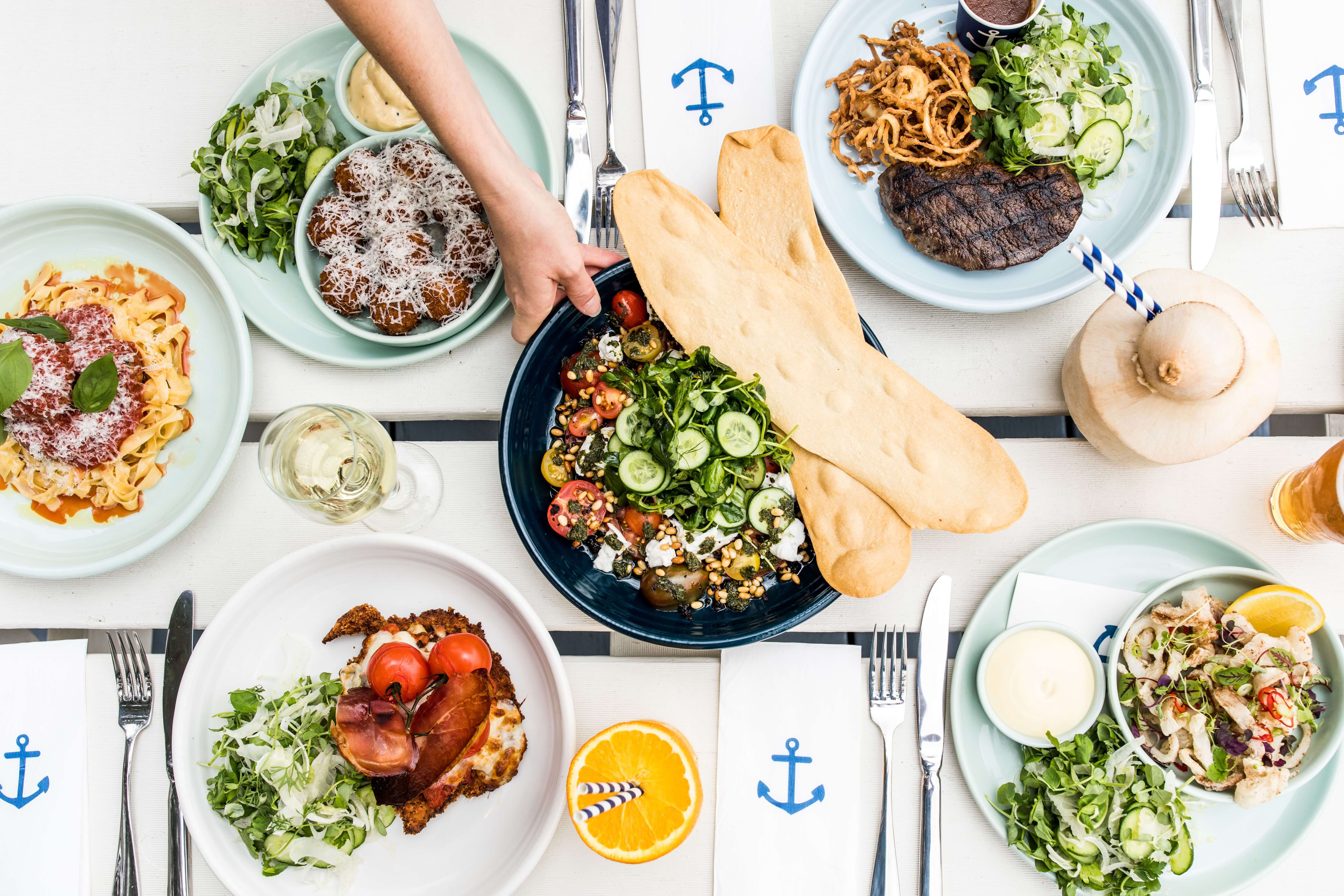 bright platter of pub food with hands picking some