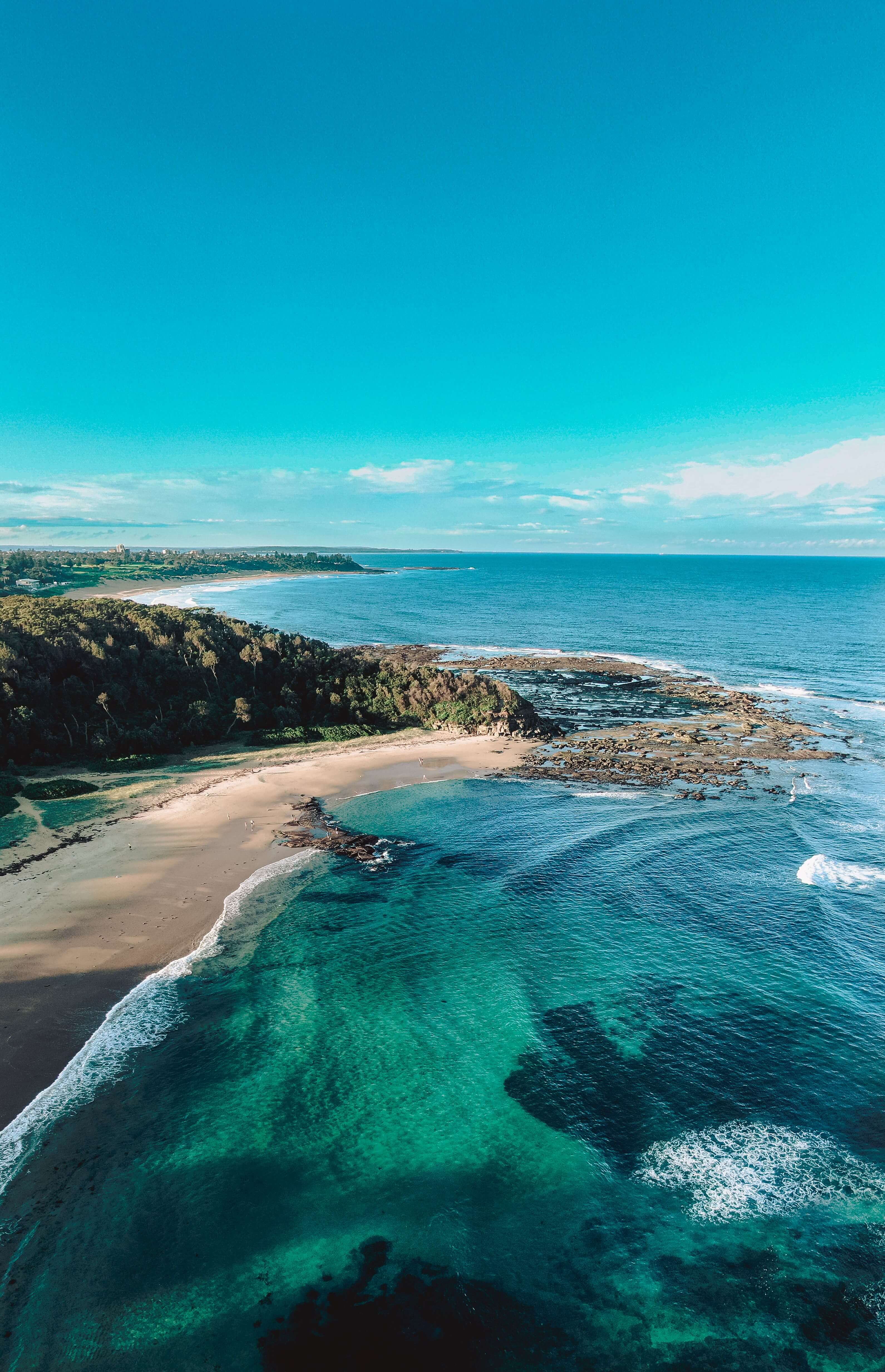 tropical beach bay with reefs visible from above