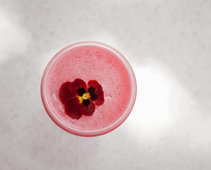 Pink cocktail with red flower in glass