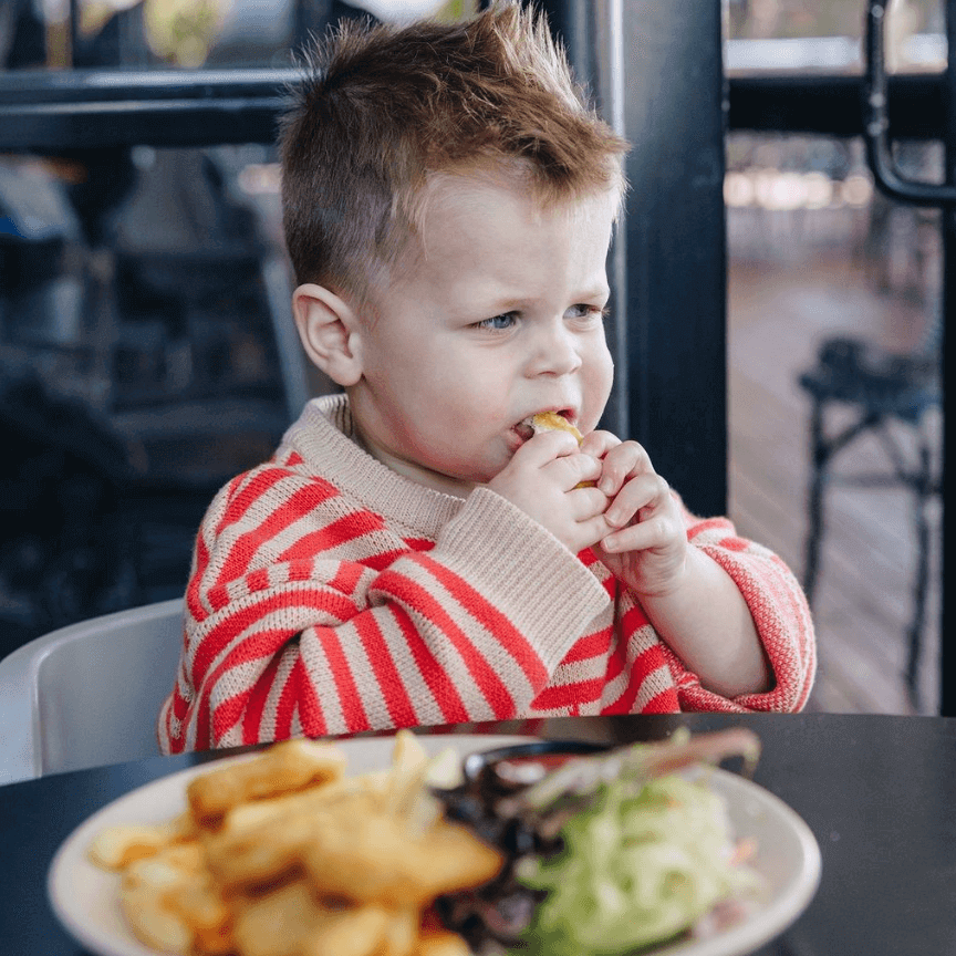 little boy eating chicken nuggets