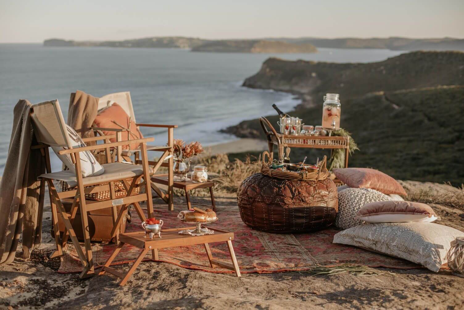 luxury lookout picnic with chairs, treats and bubbly with ocean lookout