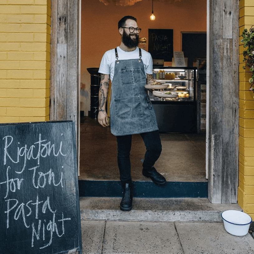 Chef in doorway carrying pasta dishes