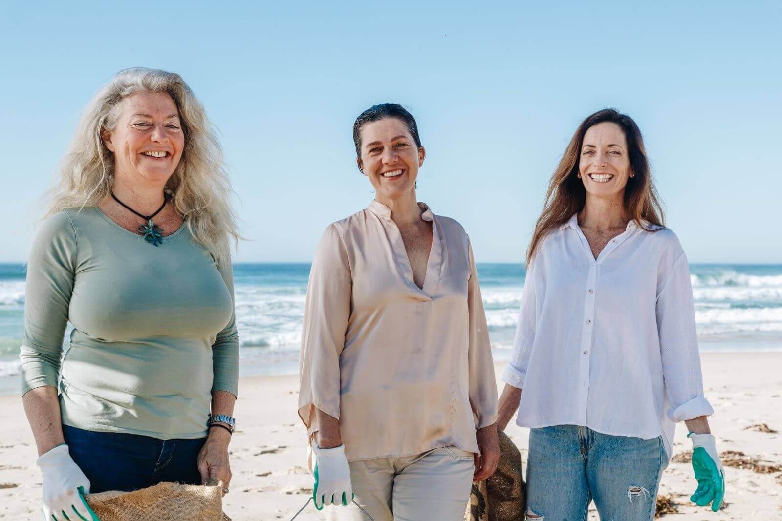 three female founders at beach cleanup