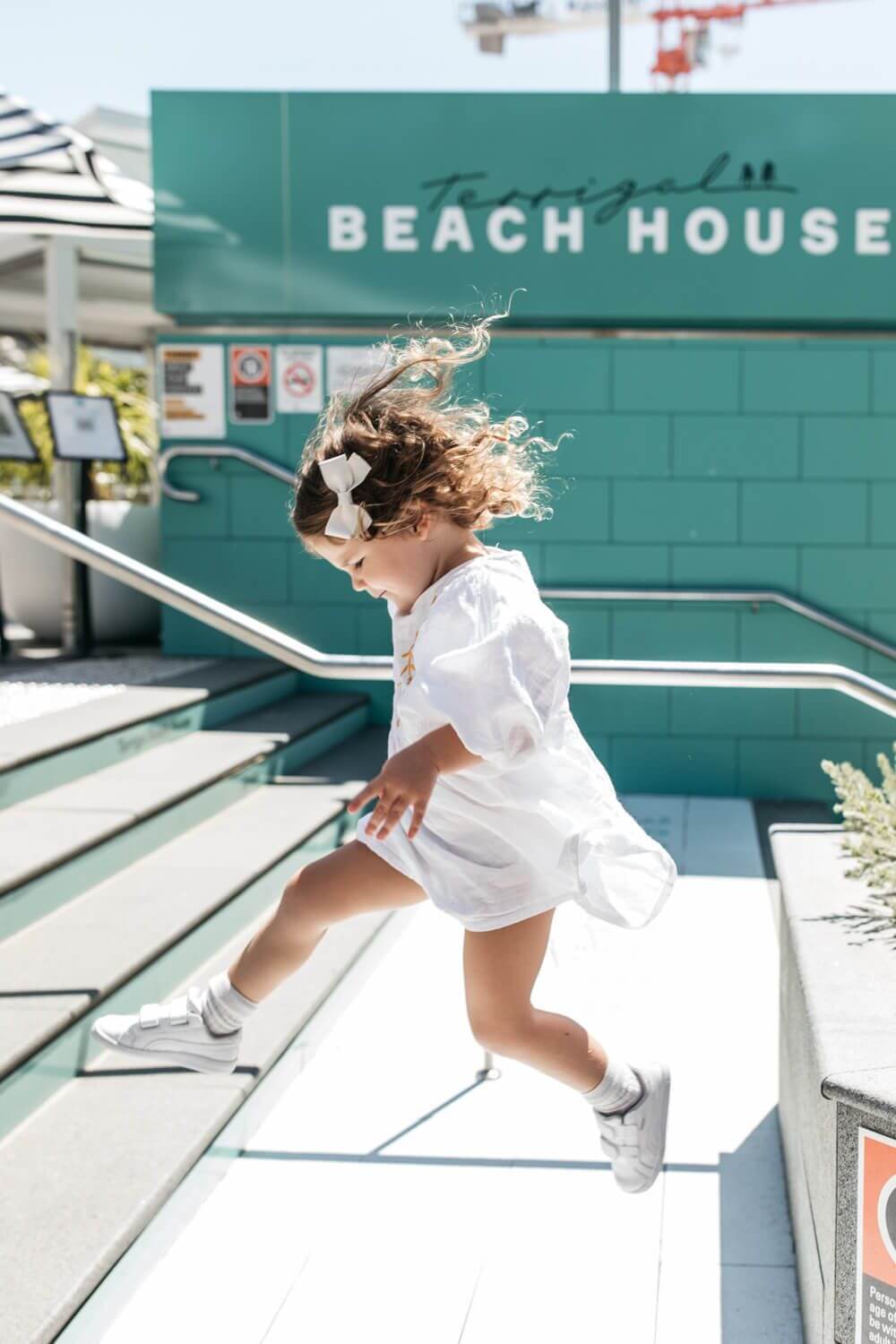 kid jumping steps of beachhouse pub