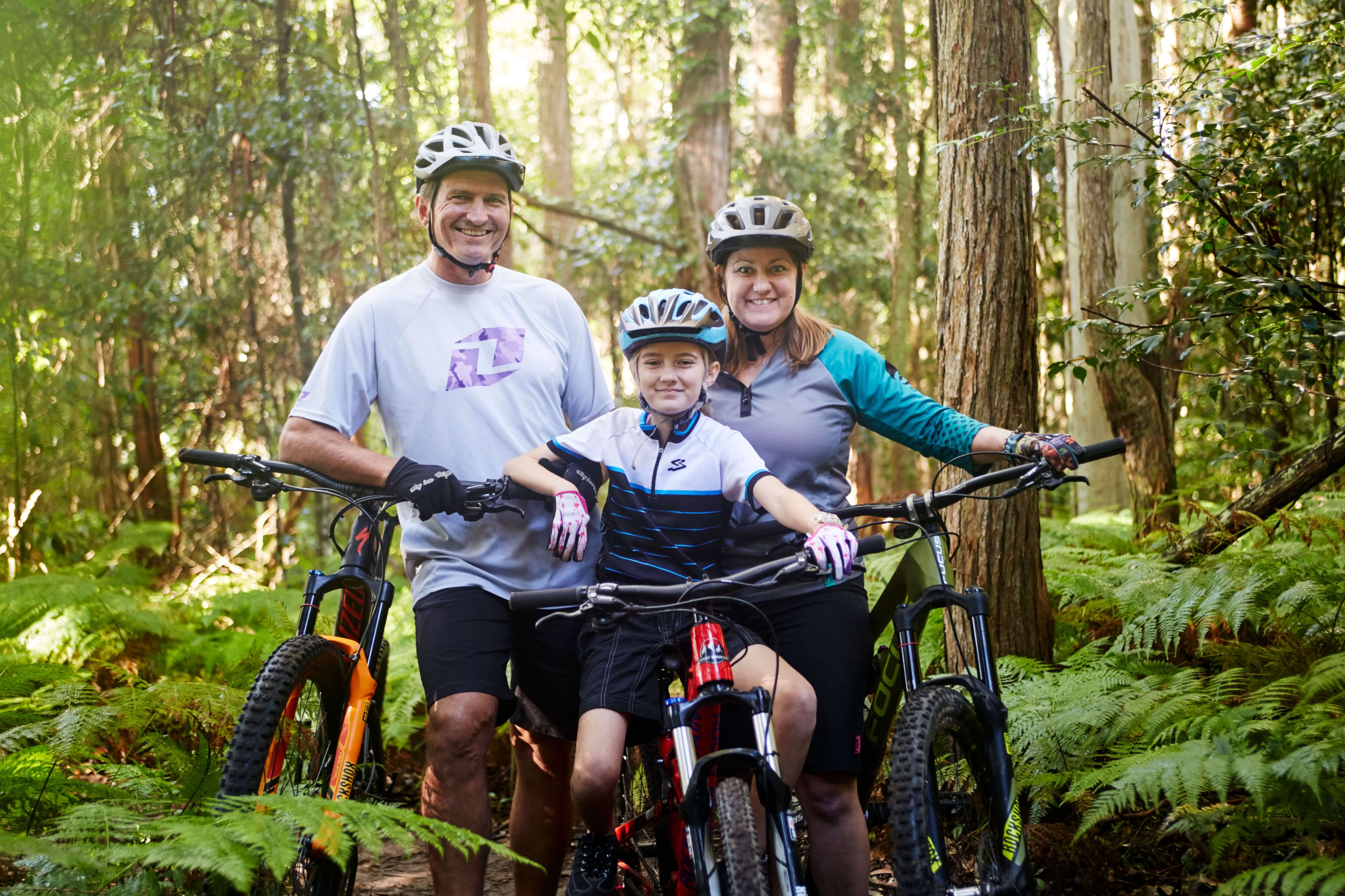 family on mountain bikes smiling happily