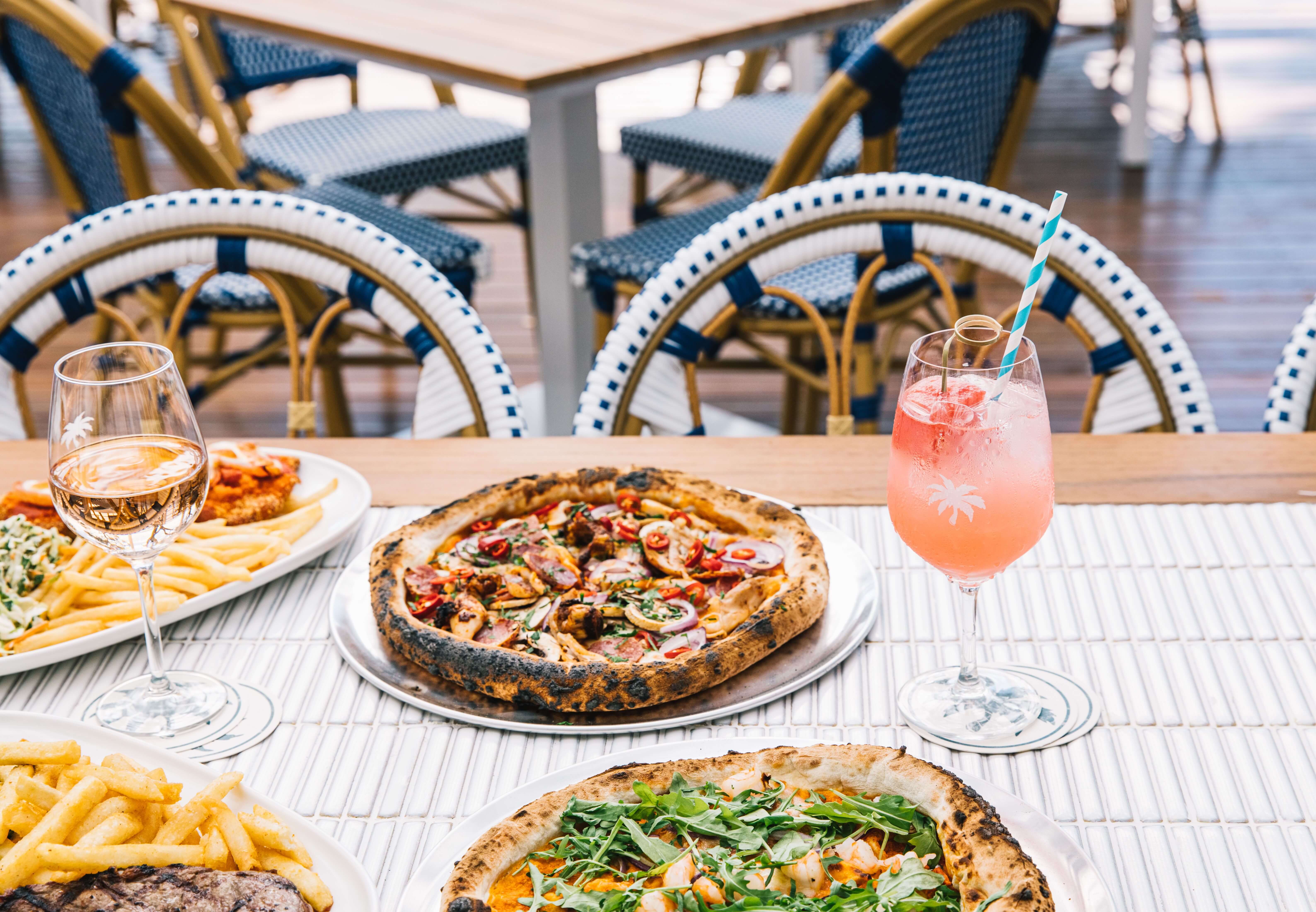 dining by the waterside with pizza on the table