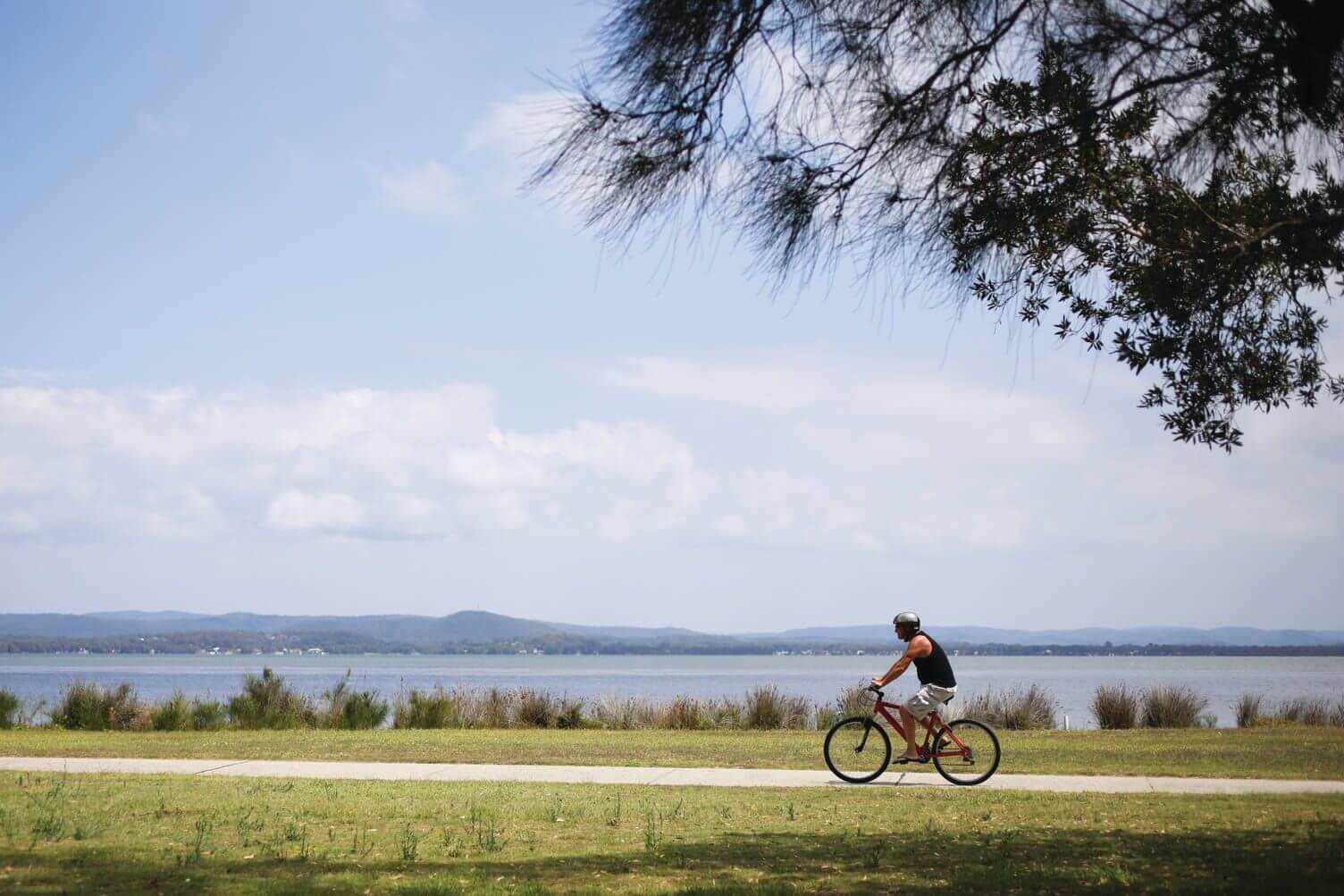bloke cycling by the lakeside