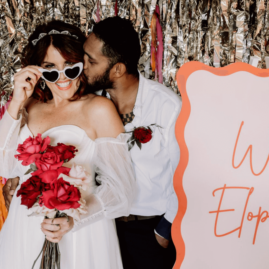 married couple with We Eloped sign