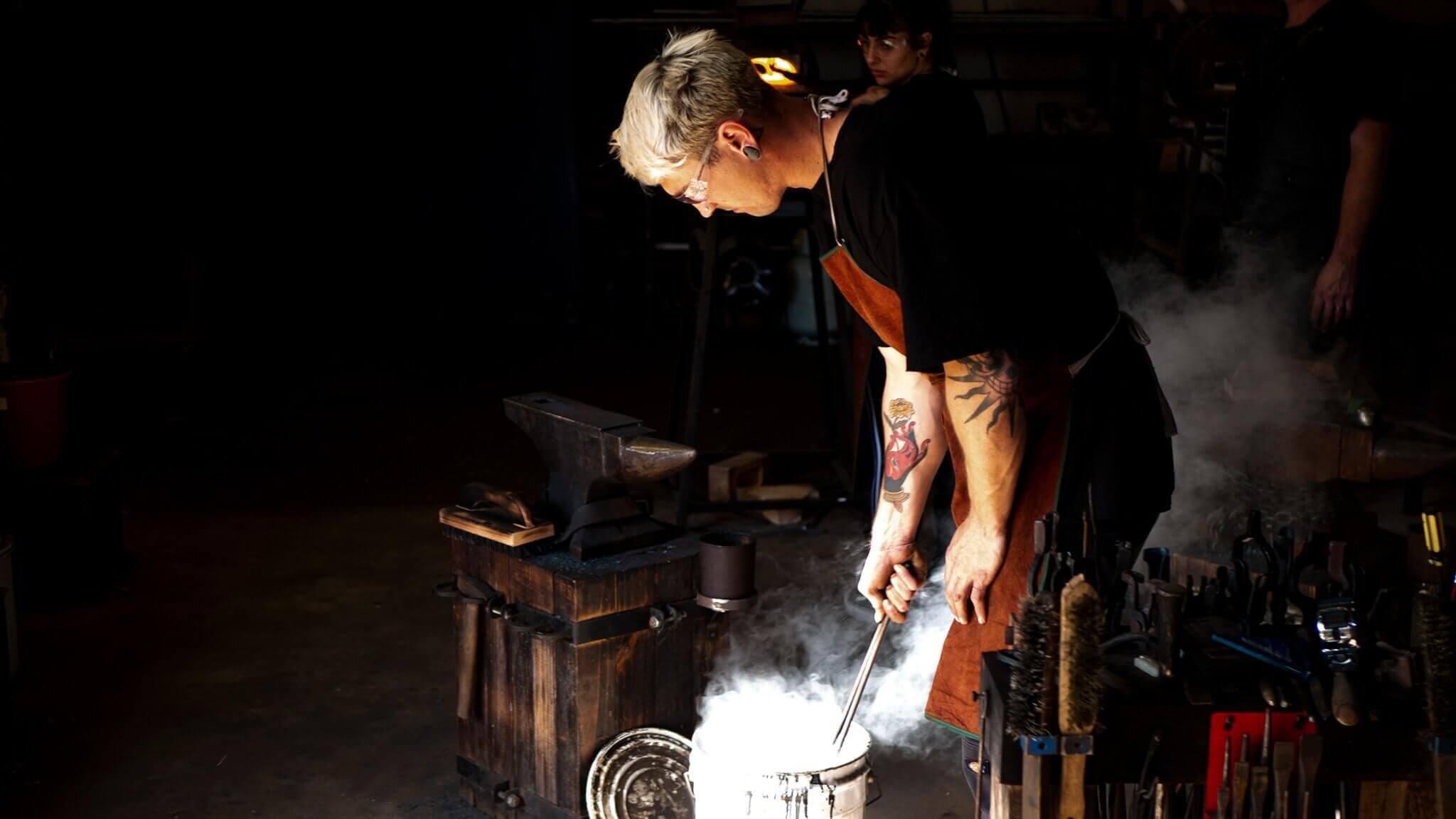 person performing blacksmithing techniques