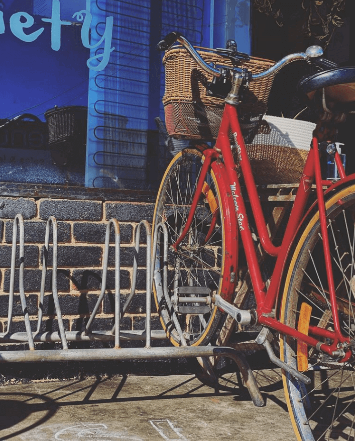 red bike on communal bike rack at cafe