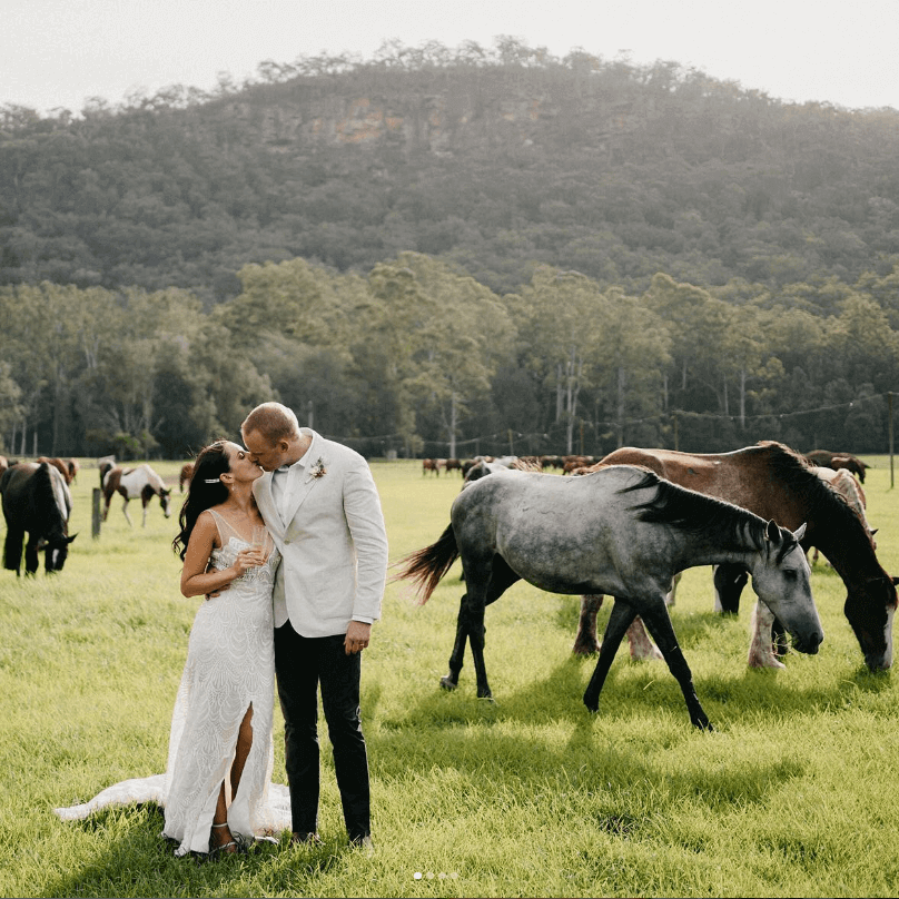 Wedding couple in field of horses