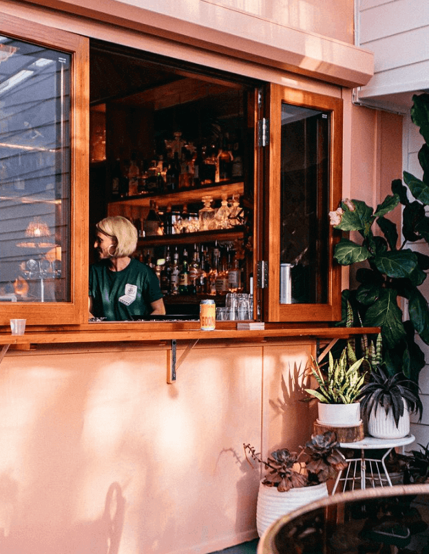 woman in sunny window with craft beer can on ledge