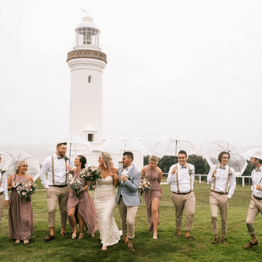 Wedding party in rain outide NOrah head Lighhouse