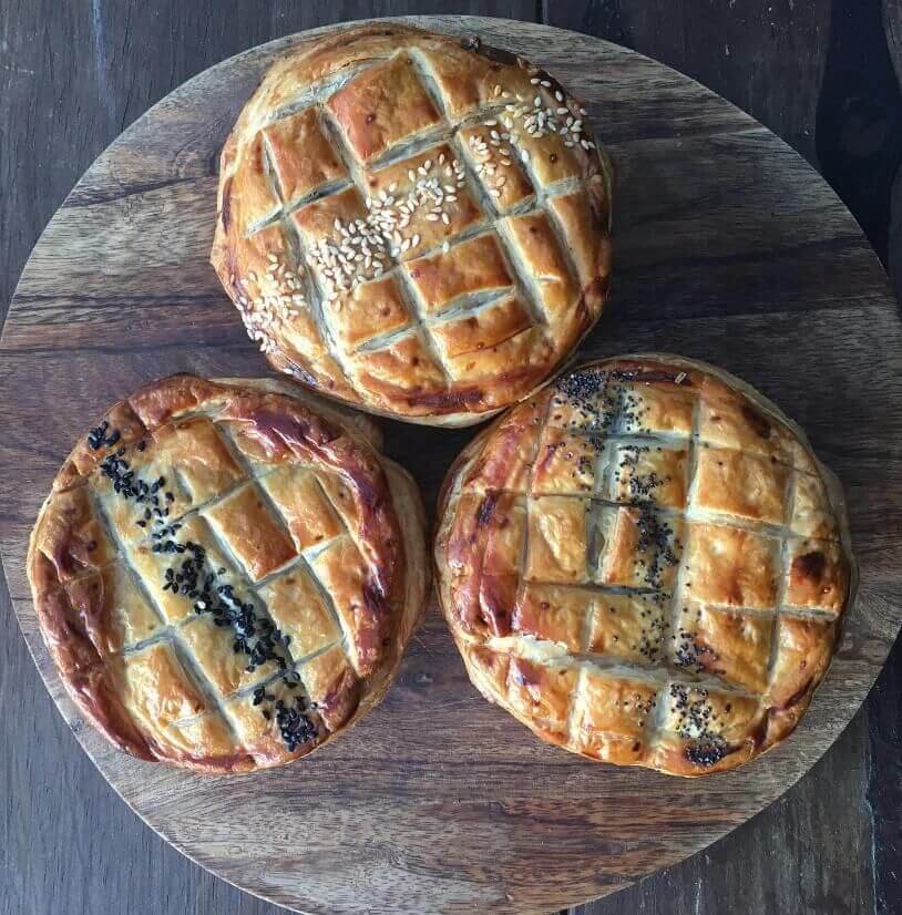 three pies on plate with herby topping