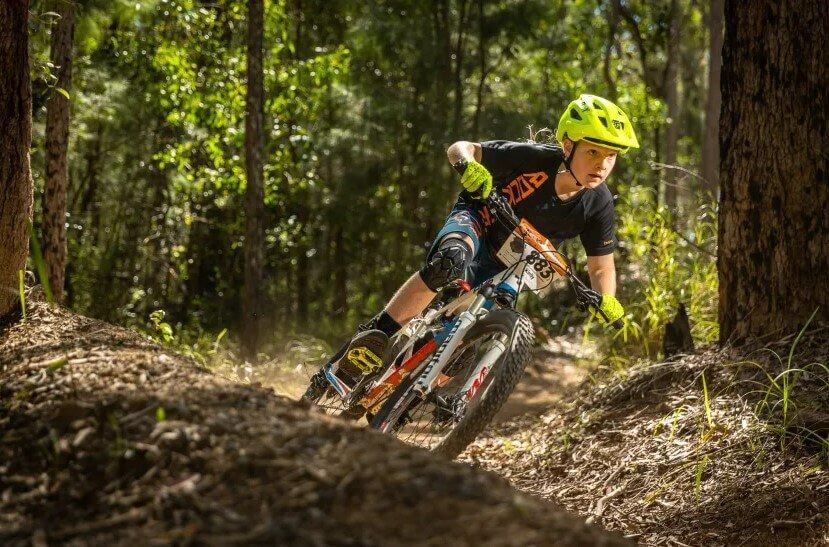 small kid mtb riding in forest setting