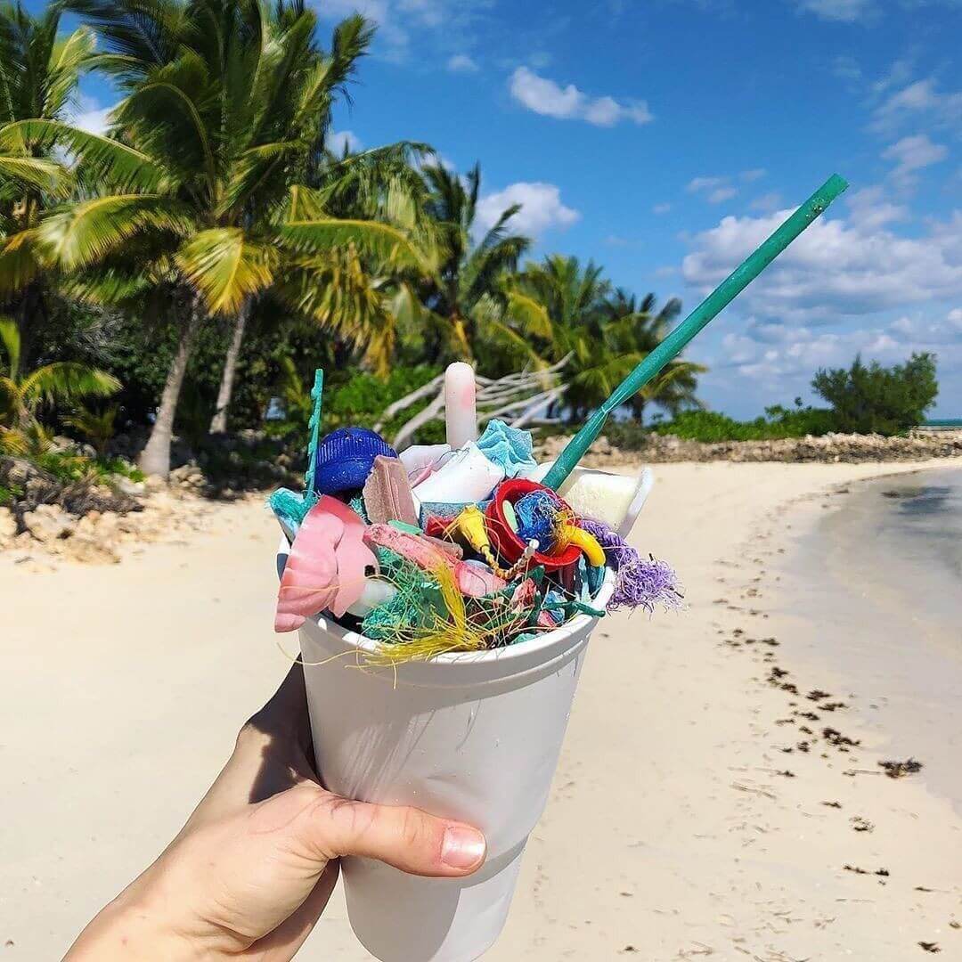 Cup full of rubbish on tropical beach