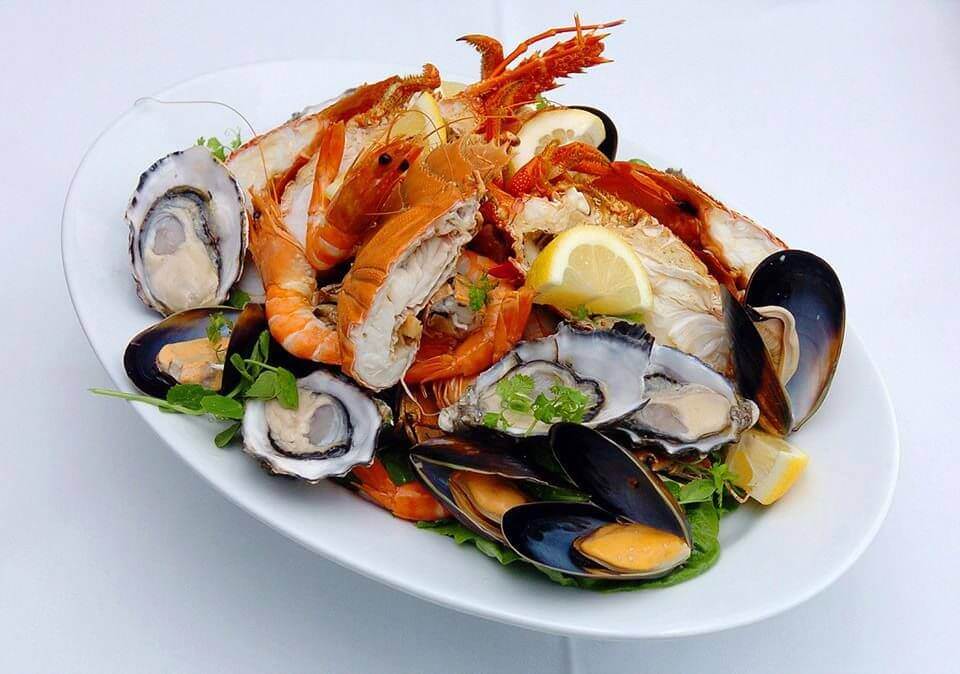 Seafood platter on white plate and white tablecloth